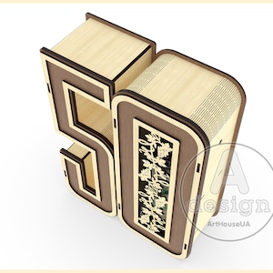 K&ouml;nnte beinhalten: Eine Holzkiste in Form der Zahl 50. Die Kiste ist aus hellem braunem Holz mit dunkelbraunen Verzierungen. Die Vorderseite der Kiste hat ein ausgeschnittenes Design aus einer Rebe mit Bl&auml;ttern und Trauben. Die Kiste ist ein dekoratives Element, das zum Aufbewahren von Kleinigkeiten verwendet werden kann.