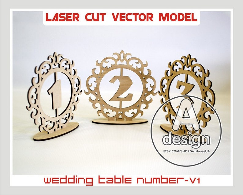 May include: Three laser cut wooden table numbers with ornate frames. The numbers are 1, 2, and 7. The numbers are designed for a wedding.