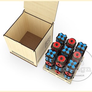 May include: A wooden box with its lid open, showing a stack of wooden blocks with red and blue X's and O's. The blocks are arranged in a pattern, and the box has a decorative design on the side.