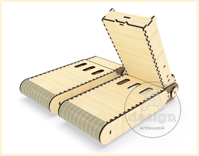 May include: A wooden phone stand with a folding design. The stand is made of light wood and has a patterned design on the bottom. The stand is open and ready to hold a phone.