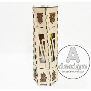 May include: A wooden box with intricate laser cut designs, perfect for storing a bottle of wine. The box is made of light wood and has a natural finish. The box is designed to hold a standard-sized wine bottle.