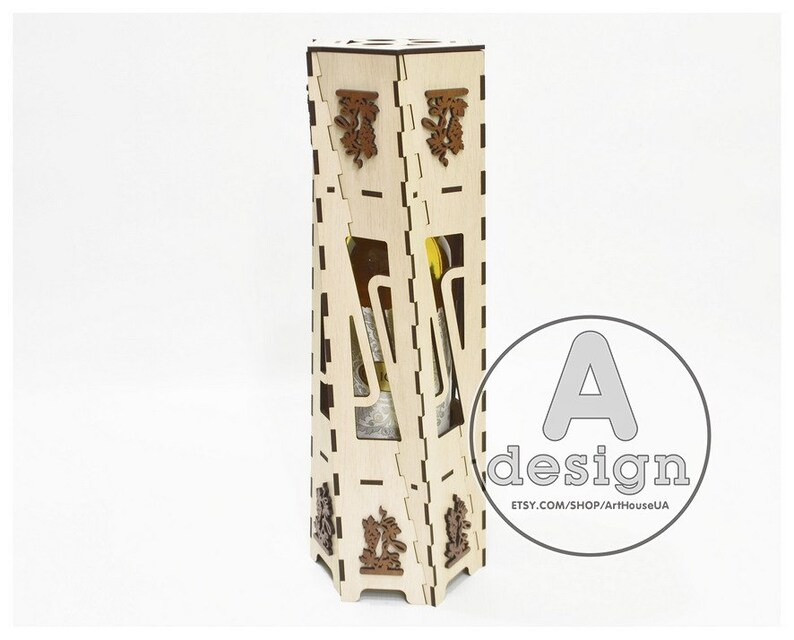 May include: A wooden box with intricate laser cut designs, perfect for storing a bottle of wine. The box is made of light wood and has a natural finish. The box is designed to hold a standard-sized wine bottle.