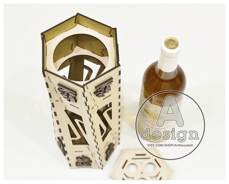 May include: A wooden wine bottle holder with a hexagonal shape and intricate laser cut designs. The holder is made of light brown wood and has a lid. The bottle holder is empty and ready to hold a bottle of wine.