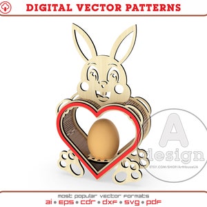 Puede incluir: Un recorte de conejo de madera que sostiene un porta huevos en forma de corazón rojo con un huevo marrón en su interior. El conejo tiene una cara de dibujos animados linda con ojos negros y una nariz roja. El porta huevos está decorado con un patrón de rayas marrones y blancas.