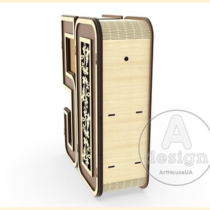 K&ouml;nnte beinhalten: Eine Holzkiste in Form der Zahl 50 mit einem dekorativen Design auf der Vorderseite. Die Kiste ist aus hellem Holz mit braunen Akzenten. Die Kiste hat ein kleines Loch auf der Vorderseite und ein paar Schlitze an der Seite. Die Kiste ist mit "A design ArtHouseUA" beschriftet.