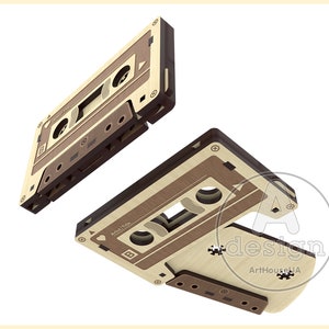 May include: Two wooden cassette tapes with a brown and beige color scheme. The tapes are floating in mid-air. The text "Artist | Title" is visible on one of the tapes.