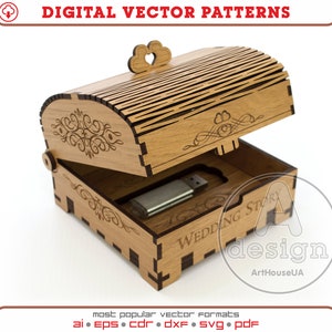 Puede incluir: Una caja de madera con tapa abatible, grabada con un corazón y las palabras "Wedding Story". La caja está abierta y se puede ver un dispositivo USB en su interior.