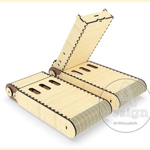 May include: A wooden phone stand with a hinged lid. The stand is made of light wood with a dark brown trim. The stand is open and the lid is propped up.