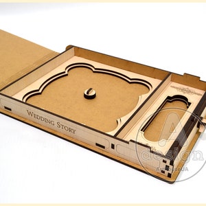 May include: A wooden box with a drawer and a cutout for a photo. The box is open and the drawer is pulled out. The box is labeled "Wedding Story".