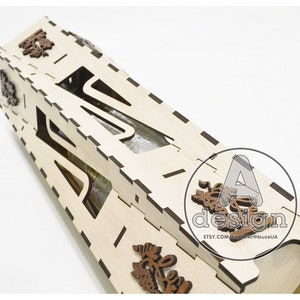 May include: A wooden bottle holder with a cutout design, featuring intricate floral details. The holder is made of light-colored wood and has a natural finish.