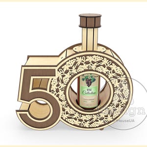 May include: Wooden wine bottle holder shaped like the number 50, with a decorative grapevine design. The holder is made of light brown wood with dark brown accents. The bottle holder is designed to hold a standard-sized wine bottle.