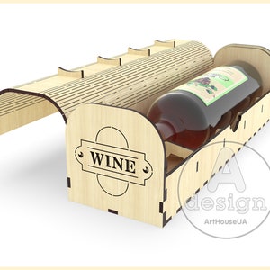 Puede incluir: Una caja de madera para vino con una tapa con bisagras y un hueco para una botella. La caja est&aacute; decorada con la palabra "WINE" y tiene un patr&oacute;n de rayas marrones y blancas.
