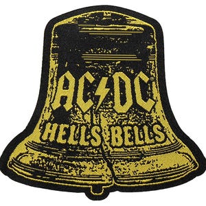 Puede incluir: Parche bordado negro y amarillo con forma de campana. El parche presenta el texto "AC/DC" con un rayo y "HELLS BELLS" en una fuente estilizada. El parche tiene un aspecto texturizado.