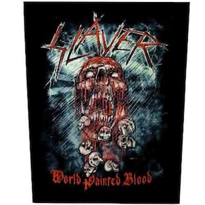 Op de afbeelding: Zwarte patch met de bandnaam "SLAYER" in rood, boven een grafische afbeelding van een bloederige schedel. De tekst "World Painted Blood" is in het rood gedrukt. Het ontwerp heeft een heavy metal esthetiek.