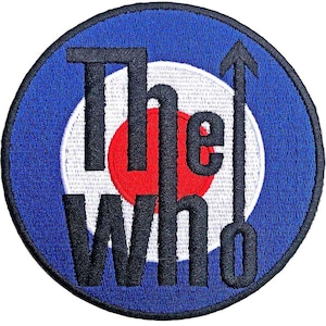 May include: Embroidered patch featuring the words "The Who" in black, with an upward arrow, set against a blue, white, and red bullseye design. The patch is circular and has a textured appearance.
