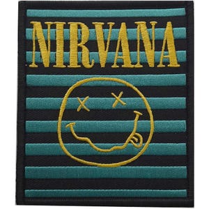 Peut inclure: Un écusson rectangulaire avec le mot "NIRVANA" en lettres dorées au-dessus d'un smiley jaune avec des yeux barrés et une langue tirée. Le fond présente des rayures horizontales noires et turquoise.
