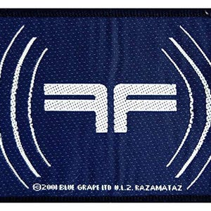 May include: A navy blue patch with a white logo featuring the letters "AF" and curved lines. The text "©2001 BLUE GRAPE LTD N.Z. RAZAMATAZ" is printed at the bottom. The patch has a black border.