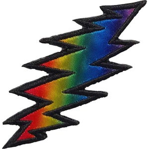 Puede incluir: Un parche de rayo de color arcoíris con un borde bordado negro. El rayo hace la transición del rojo al naranja, amarillo, verde, azul y morado. Este parche bordado es adecuado para chaquetas, bolsos u otros artículos de tela.