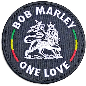 Può includere: Toppa rotonda nera con le parole "BOB MARLEY ONE LOVE" in bianco. Un leone bianco con una corona è al centro. La toppa ha una striscia verde, gialla e rossa sui lati sinistro e destro.