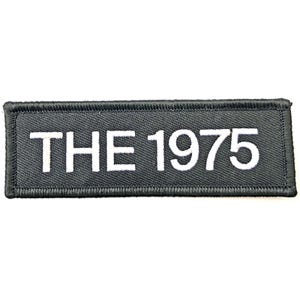 May include: A rectangular black patch with white embroidered text that reads "THE 1975". The patch has a black border and is likely designed to be sewn or ironed onto clothing or accessories. The text is in a bold, sans-serif font.