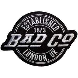 Puede incluir: Parche bordado en blanco y negro con el texto "BAD CO" en negrita. El parche es circular con las palabras "ESTABLISHED 1973" y "LONDON, UK" en un diseño circular alrededor del texto central.