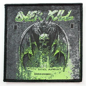 May include: Square patch with a black border featuring the text "OVER KILL" in green, above a detailed illustration of a winged demon with a skull. The text "WHITE DEVIL ARMORY" and copyright information are below the illustration.