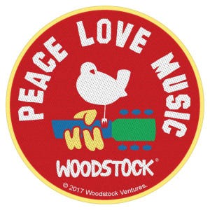 May include: Circular patch with a red background and a yellow border. The patch features the words "PEACE LOVE MUSIC" in white, surrounding a white dove perched on a guitar. The word "WOODSTOCK" is at the bottom.