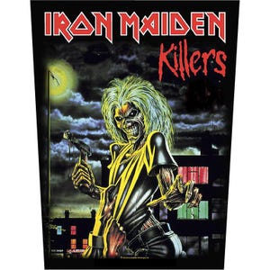 May include: A black Iron Maiden "Killers" patch featuring Eddie, the band's mascot, holding a weapon. Eddie has green hair and a skeletal face, set against a night scene with a full moon and buildings. The band's name and album title are in red.