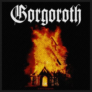 May include: A black patch with the band name "Gorgoroth" in white gothic script. Below is an illustration of a church on fire, with flames in shades of red and yellow. The image has a textured background and the text "© 2013 Gorgoroth".