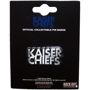 May include: A black backing card with a silver-colored Kaiser Chiefs pin badge. The text "KAISER CHIEFS" is displayed in a bold, metallic font. The card also features the text "OFFICIAL COLLECTABLE PIN BADGE".