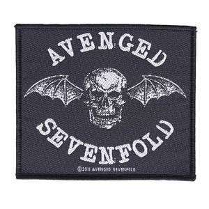 Puede incluir: Parche rectangular negro con las palabras "AVENGED SEVENFOLD" en blanco, arqueadas sobre y debajo de una calavera con alas de murciélago. El texto "©2011 AVENGED SEVENFOLD" está en la parte inferior. El parche tiene un borde negro.