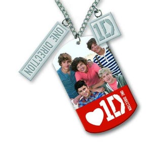 May include: A silver chain necklace featuring multiple pendants. The main pendant is a red dog tag with a photo of five young men and the text "1D" and "ONE DIRECTION". Additional pendants include a rectangular tag with "ONE DIRECTION" and a square tag with "1D".