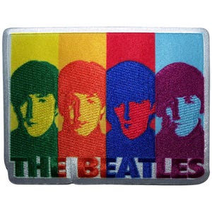 Op de afbeelding: Geborduurde patch met de Beatles. De rechthoekige patch met witte rand toont de gezichten van de bandleden in een rij, elk in een andere kleur: groen, geel, rood, blauw en paars. De tekst "THE BEATLES" staat onderaan.