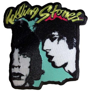 May include: Embroidered patch with a black and white image of two faces, and the words "Rolling Stones" in gold and red. The patch has a black border and a teal background.