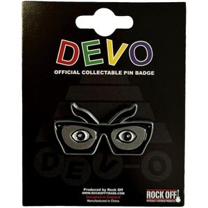 May include: A black pin badge featuring the word "DEVO" in red, yellow, and purple. The pin has a silver-colored glasses design. The text "OFFICIAL COLLECTABLE PIN BADGE" is above the glasses.