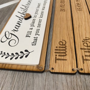 May include: Wooden sign with the text "Grandchildren Fill a place in your heart that you never knew was empty" and three smaller wooden signs with the names "Tillie", "Tyler" and the dates "31/12/20", "15/08/20", "12/07/20".