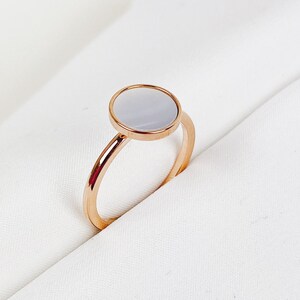 K&ouml;nnte beinhalten: Ein Ring aus Ros&eacute;gold mit einem wei&szlig;en, runden Perlmuttstein.
