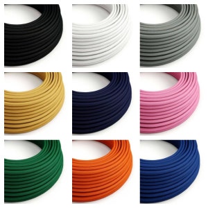 Op de afbeelding: Negen spoelen met stof bekleed elektrische draad in verschillende kleuren, waaronder zwart, wit, grijs, geel, donkerblauw, roze, groen, oranje en blauw.