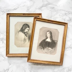 Peut inclure: Deux portraits anciens encadrés avec des cadres dorés. Les portraits sont des croquis en noir et blanc de femmes. Les cadres ont un aspect vintage et vieilli. Le fond est une surface à motifs de marbre.