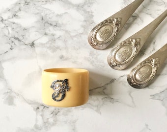 Very beautiful antique napkin ring in white bakelite or celluloid imitating ivory, and bearing the monogram F in silver metal