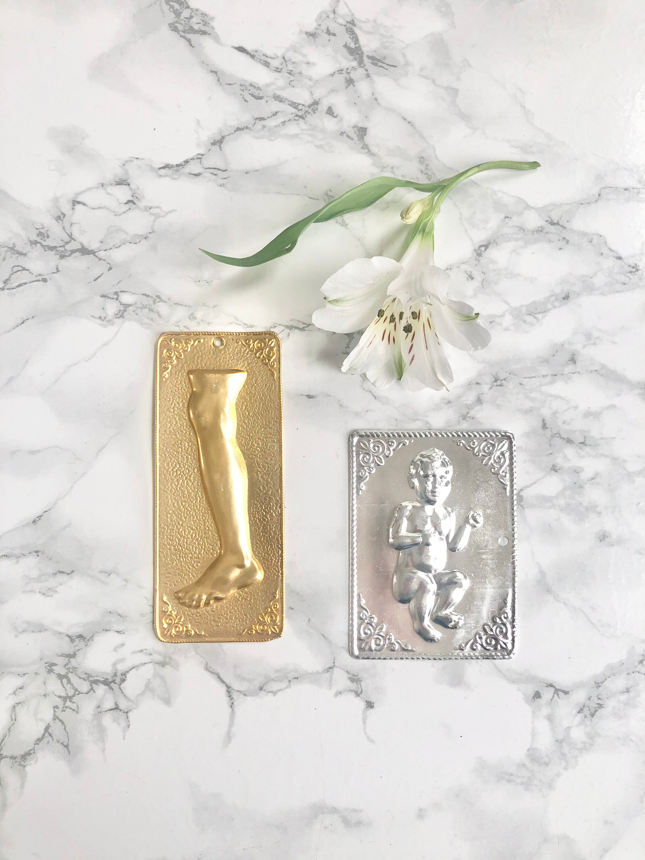 Ensemble de Deux Ex-Voto Grecs en Métal Représentant Un Bébé et Une Jambe