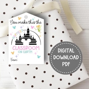 Puede incluir: Una etiqueta de regalo con el texto "You make this the happiest classroom on earth" con un diseño de castillo y orejas de Mickey Mouse. La etiqueta está en un regalo envuelto con un patrón de lunares y una cinta.