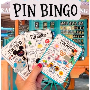 May include: Three rectangular Pin Bingo game cards featuring grid layouts with various icons and text labels including Disneyland, Accessories, and California Adventure. The cards display colorful enamel pins attached to the surface of the paper.