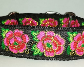 Könnte beinhalten: Schwarzes Hundehalsband mit floralem Design. Der Kragen zeigt gestickte rosa und rote Rosen mit grünen Blättern und goldenen Akzenten. Der Kragen hat silberne Metallbeschläge.