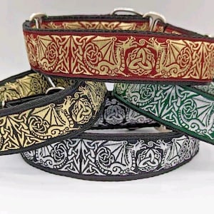 May include: A stack of dog collars with ornate dragon and knot designs. The collars feature a variety of colors, including gold on burgundy, gold on black, silver on white, and silver on green. Each collar has a black backing and silver hardware.