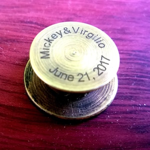 May include: A gold-colored metal disc with the inscription "Mickey & Virgilio June 21, 2017".