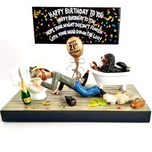 Op de afbeelding: Een humoristisch verjaardagsbeeldje met een man die over een toilet hangt, een hond in een badkuip en een bord met de tekst "HAPPY BIRTHDAY TO YOU". Het beeldje bevat een champagnefles en een ballon met "HAPPY 21st BIRTHDAY!"