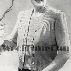Könnte beinhalten: Nahaufnahme einer Frau, die einen gestrickten Cardigan mit Knopfleiste und Rippenstruktur trägt. Der Cardigan ist hellgrau und hat einen V-Ausschnitt. Die Frau lächelt und blickt nach rechts. Der Text "WooltimeFun" ist in der linken unteren Ecke des Bildes sichtbar.