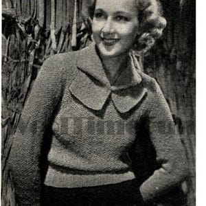 Könnte beinhalten: Nahaufnahme einer Frau, die einen Strickpullover mit einem großen, umgeklappten Kragen trägt. Der Pullover ist hellbraun und hat ein strukturiertes Strickmuster. Die Frau lächelt und schaut zur Seite.