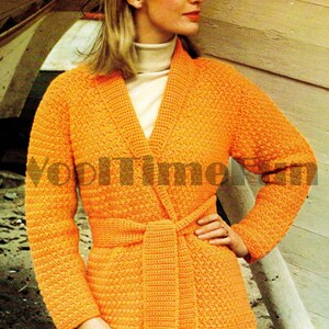 May include: A bright orange crocheted cardigan with a long sash tie and a fringe detail. The cardigan has a shawl collar and long sleeves.